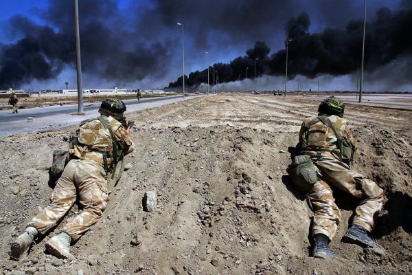 Two British soldiers take up position on the road to Basra as burning oil fills the sky April 2nd,2003.

pic:Paul Hackett